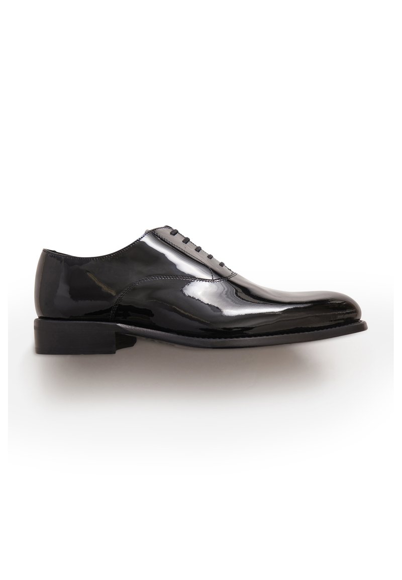 Scarpa nera da uomo con finitura in vernice lucida e liscia. Presenta sei occhietti per i lacci e un tacco basso impilato. Forma classica della punta arrotondata.