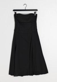 Černé šaty bez ramínek s vertikálními sklady na předním díle, splývavou sukní a hladkou texturou. Visí na černém plastovém ramínku.