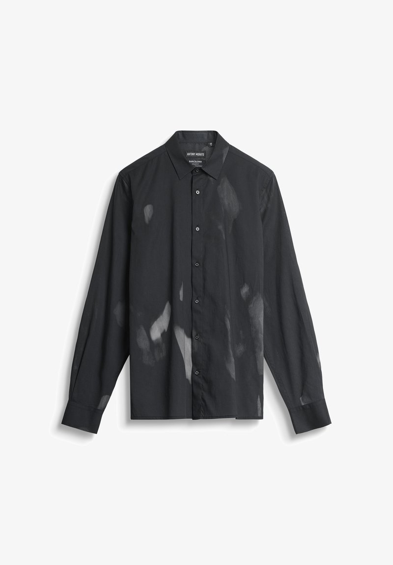 Camisa negra de manga larga con cuello abotonado y patrones moteados en gris claro a lo largo de la tela, fabricada con un material suave.