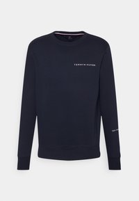 Felpa a maniche lunghe blu navy con colletto rotondo, con piccolo logo bianco "Tommy Hilfiger" sul petto e testo "New York" sulla manica.