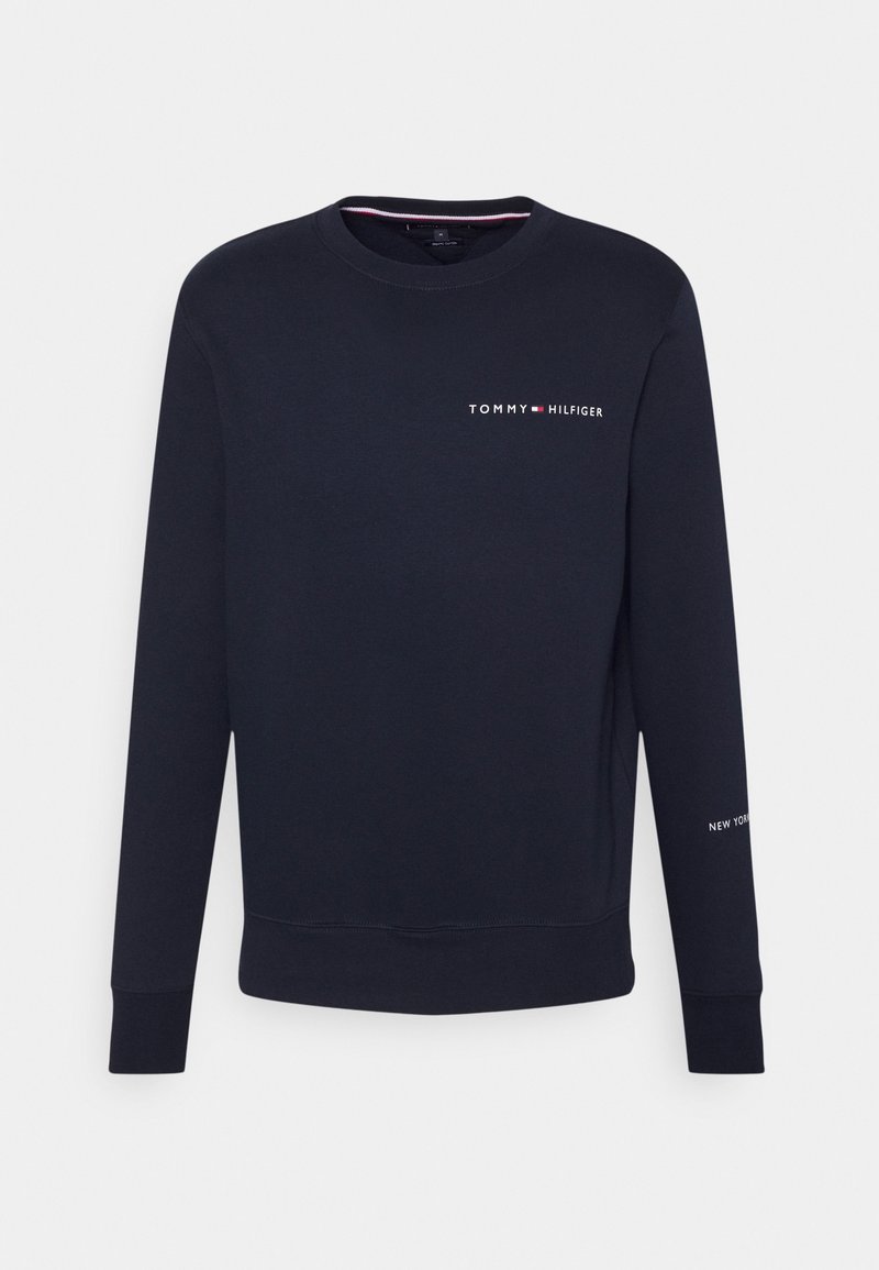 Sweatshirt à manches longues bleu marine avec col rond, présentant un petit logo blanc "Tommy Hilfiger" sur la poitrine et le texte "New York" sur la manche.