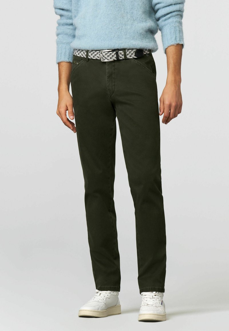 Donkergroene katoenen broek met een slanke pasvorm, met voorzakken, een gestructureerde grijs-zwarte riem en gecombineerd met witte sneakers.