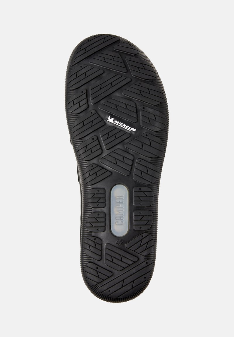 Schwarze Gummisohle mit strukturierten Profilmustern und Markendetails für Michelin und Camper. Größe 42 sichtbar.