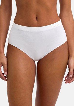 Gros plan sur une personne portant un sous-vêtement blanc taille haute sans coutures avec une texture côtelée et un petit logo sur la ceinture.
