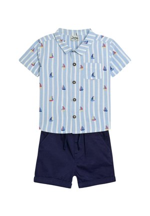 Cămașă cu mânecă scurtă și nasturi, de culoare albastră deschisă, cu dungi albe și modele colorate de veliero, purtată cu pantaloni scurți bleumarin, prevăzuți cu buzunare.
