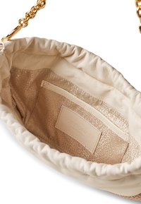 Cremefarbene Lederhandtasche mit gerafftem Oberteil, goldener Kettenriemen und glattem Innenraum mit einem geprägten Muster und einer kleinen Tasche.