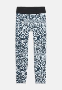 Leggings bleu marine avec un motif rayé blanc de zèbre. Dotés d'une large ceinture noire. Fabriqués en matériau extensible et lisse.