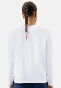 Witte longsleeve T-shirt met een losse pasvorm, zachte textuur en een ronde halslijn, voorzien van zijslits aan de zoom.