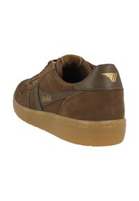Baskets en daim marron avec une semelle en caoutchouc couleur gomme, présentant une bande marron foncé et des accents en or sur le côté et le talon.