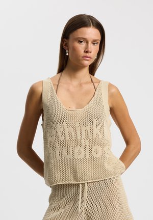 Débardeur beige en maille avec une coupe ample, un tissu à maille ouverte et le texte découpé "rethinks studios." Associé à un short assorti.