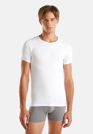 T-shirt bianco a maniche corte realizzato in tessuto liscio, con collo rotondo, design aderente e cuciture minime, abbinato a boxer grigi.