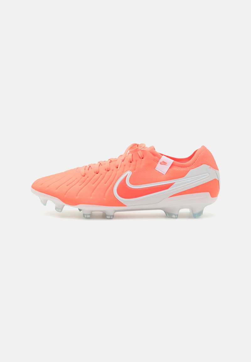 Nike nogometne kopačke u svijetloj koraljnoj boji s bijelim detaljima, s teksturiranom gornjom površinom, sustavom vezanja i prozirnim kramponima za bolje prianjanje.