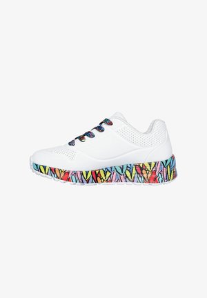 Baskets blanches avec une tige texturée, semelle multicolore à motifs avec des designs en forme de cœur, et lacets décoratifs aux couleurs vives.