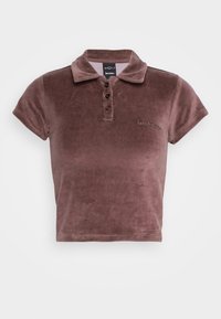 Sametová polo košile ve tlumené mauvě, s límcem, čtyřmi knoflíky a krátkými rukávy. Vyšívaný text na levé hrudi.