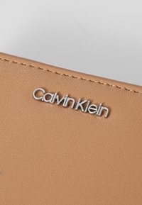 Calvin Klein MUST MEDIUM ZIP AROUND WALLET - Portafoglio - lion
