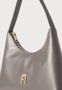 Sivá kožená kabelka cez rameno s hladkým povrchom. Zdobená zlatým zipsom a zlatým logom. Zakrivený tvar s jedným popruhom.