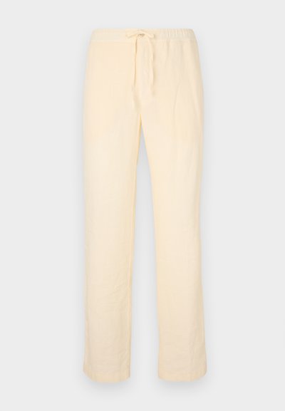 Svetložlté, voľné nohavice vyrobené z mäkkej tkaniny, s elastickým pásom na šnúrku a rovnými nohavicami.