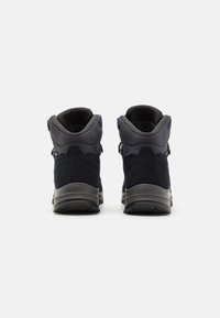 Σκοτεινές μπλε μποτές πεζοπορίας με σουέτ και συνθετικό άνω μέρος, αντίθετους τόνους στη φτέρνα και υφασμάτινες ραβδώσεις. Η πίσω όψη δείχνει επενδεδυμένα κολάρα.