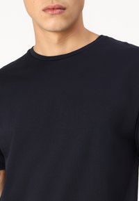 Navy blue cotton t-shirt with a round neck and short sleeves. Smooth texture, minimal seams, and no visible patterns or accents.