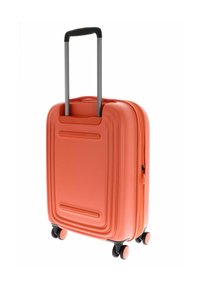 Maleta rígida de color coral con un diseño texturizado, mango retráctil y cuatro ruedas negras para una fácil movilidad. Cierre con cremallera visible.