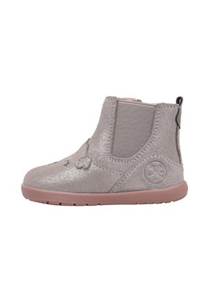 Bota de ante gris claro para niño con suela rosa, panel lateral elástico, lengüeta en el talón y pequeños detalles decorativos de corazón y flor.