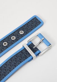 Modrý a námořnický pásek vzorovaný látkou s kovovou sponou v barvě stříbra a kroužky. Branding viditelný na sponě. Hladká textura a kontrastní okraje.