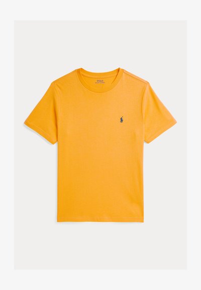 Īsām piedurknēm, spoži dzeltena t-krekls, izgatavots no mīkstas kokvilnas. Iekļauj klasisku apaļu kakla izgriezumu un mazu zilu logo uz krūtīm.