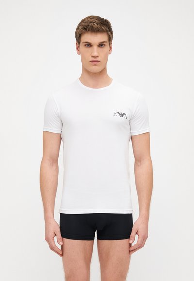 White short-sleeve T-shirt made of cotton, featuring a round neckline and a small black logo on the chest. Smooth texture with minimal detailing.