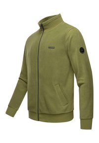 Vihreä fleece-takki, jossa on korkea kaulus, etuvetoketju, sivutaskut, ribbineuleet hihansuissa ja helmassa sekä musta logopatchi hihassa.