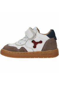Witte leren en bruin suède kindersneaker. Heeft een rode accent, een gevoerde tong, veters met klittenbandsluiting en een gestructureerde rubberen zool.