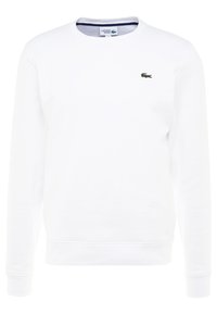 Vit sweatshirt med långa ärmar, rund halsringning och ribbade mudd. Har en liten grön Lacoste-logotyp på vänster bröst. Mjukt material.