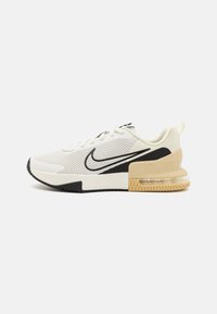 Nike kedu baltā sietā ar melniem akcentiem. Piedāvā strukturētu papēdi ar caurspīdīgu gaisa spilvenu un gumijas zoli ar šūnveida rakstu.
