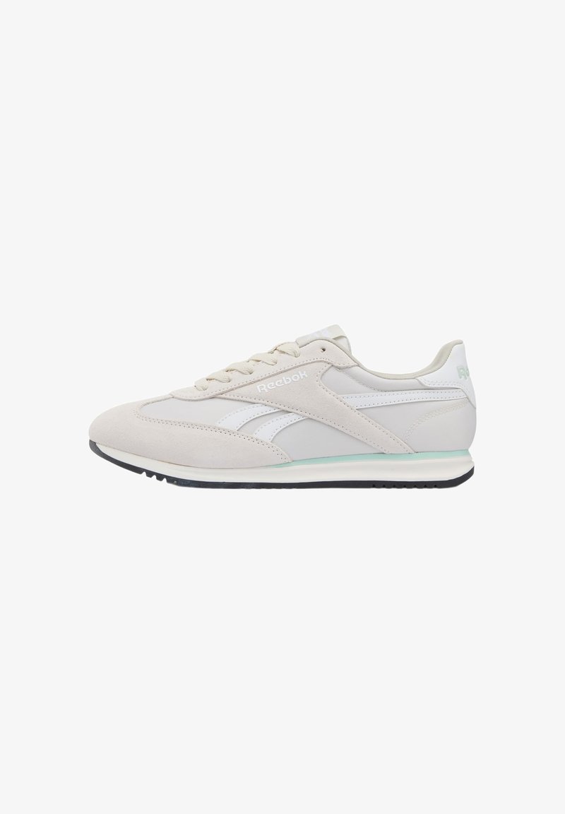 Baskets Reebok beige clair avec des bandes blanches, des lacets blancs et une semelle noire, vues de profil extérieur sur fond blanc.
