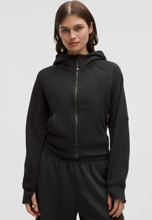 Hanorac negru cu fermoar, cu un design ajustat, care prezintă un guler înalt, buzunare tip kangaroo și detalii ribbate. Fabricat dintr-un material moale, texturat.