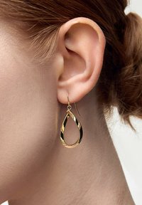 Złote kolczyki w kształcie kropli o polerowanym wykończeniu, z pustym wnętrzem i prostym zapięciem na haczyk. Eleganckie i lekkie, idealne do codziennego noszenia.