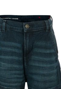 Donkerblauwe denim shorts met een textuurafwerking. Voorzien van een knoopsluiting aan de voorkant en lussen voor een riem. De binnenband heeft een met patroon gedecoreerde voering.