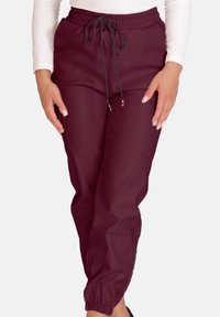 Bordeauxrote Jogginghosen aus einem weichen, glatten Stoff mit elastischem Bund, verstellbarem Kordelzug und seitlichen Taschen; verjüngte Beinabschlüsse am Knöchel.