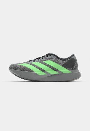 Sportschoenen met een bovenkant in grijs en zwart patroon, voorzien van drie felgroene strepen; lichtgewicht ontwerp en platte zool.