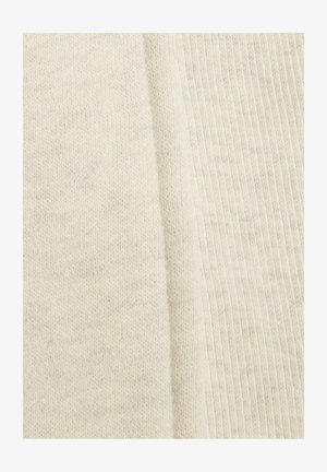 Tejido de punto blanco con una superficie suave y texturizada; los patrones acanalados visibles y ligeras variaciones en el color añaden profundidad al material.