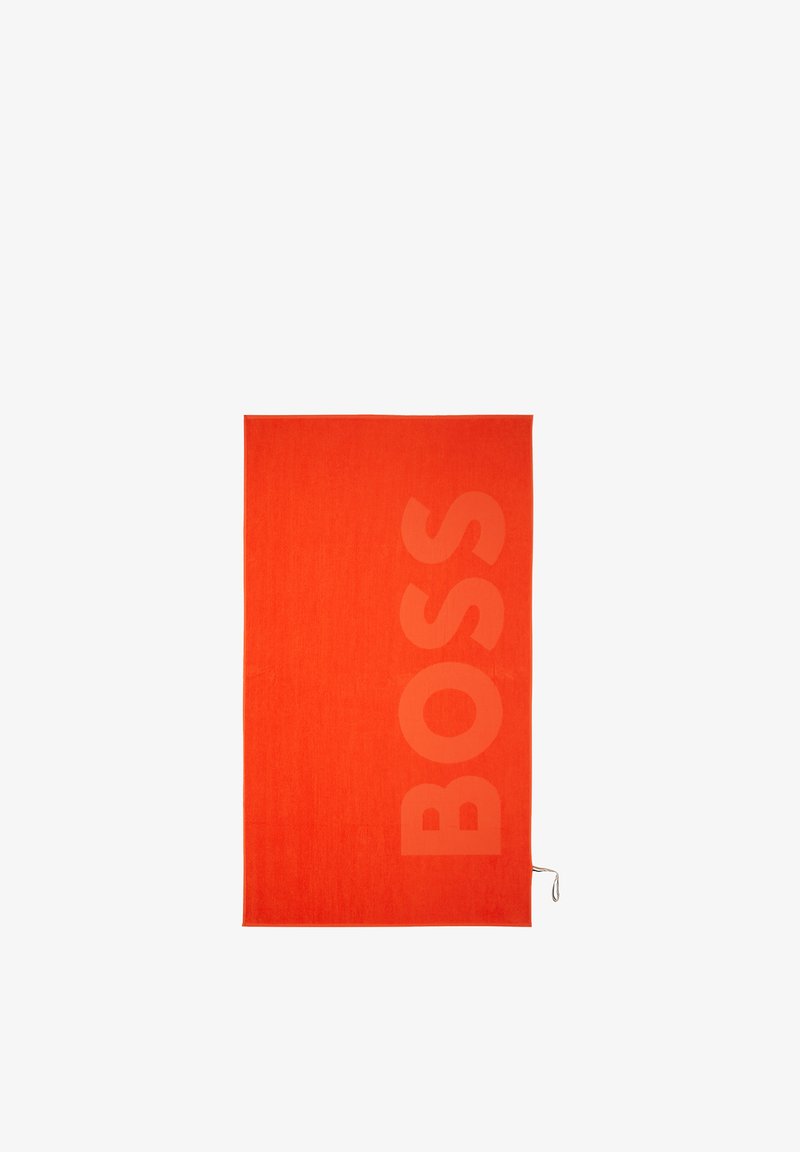 Serviette rectangulaire orange vif avec le mot "BOSS" embossé verticalement en grandes lettres sur le côté droit.