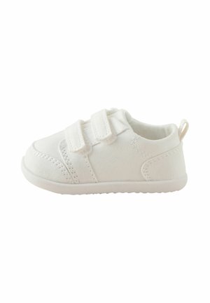 Zapato blanco para niño pequeño con dos tiras de velcro, suela texturizada, lazo de tela en el talón y detalles visibles de costura.