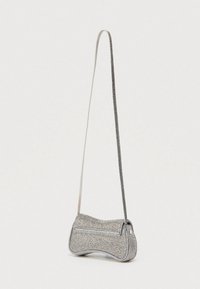 Geantă de mână metalică argintie cu formă rotunjită, suprafață texturată, închidere cu fermoar și o curea subțire pentru purtarea pe umăr.