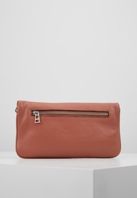 Prostokątna skórzana kopertówka w stonowanym koralowym kolorze, z wyraźną srebrną kieszenią na zamek błyskawiczny z przodu oraz gładką, teksturowaną powierzchnią.