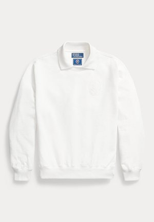 Biely dlhý rukáv mikiny s golierom, rebrovanými manžetami, vyšívaným emblémom na hrudi a štítkom Polo by Ralph Lauren vo vnútri goliera.
