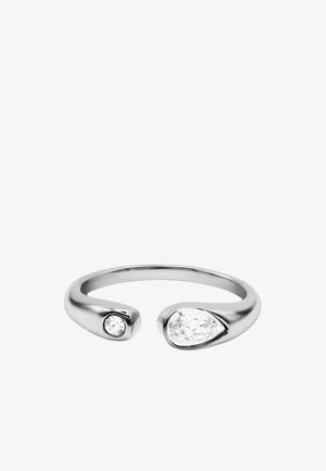 Anillo abierto de plata con un pequeño diamante redondo en un extremo y un diamante más grande en forma de pera en el otro extremo.