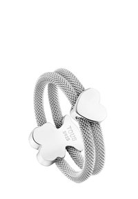 Srebrny pierścionek z podwójną siateczkową opaską ozdobiony sercem i misiem, oznaczony "TOUS S925", charakteryzuje się gładkim, polerowanym wykończeniem i splatającym się wzorem.