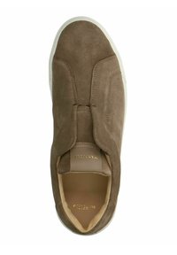Chaussure à enfiler en daim marron avec une texture lisse, présentant un design minimaliste et une semelle en caoutchouc blanche. Lettrage de la marque en doré à l'intérieur.