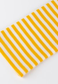 Yellow and white horizontal striped fabric with visible stitching along the edge, laid flat on a white background.