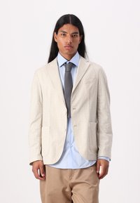 Light beige tailored blazer made of textured fabric, featuring a two-button closure, notched lapels, and two front pockets.