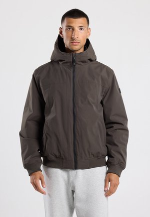Chaqueta de cremallera marrón oscuro con capucha, que presenta una textura suave, puños y dobladillo acanalados, y dos bolsillos frontales.